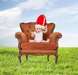 Image showing baby in royal hat with lollipop sitting on chair