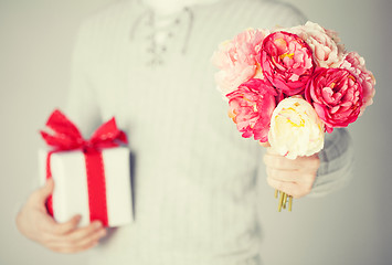 Image showing man holding bouquet of flowers and gift box