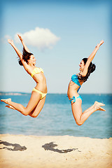 Image showing girls jumping on the beach