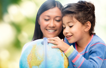 Image showing happy mother and daughter with globe