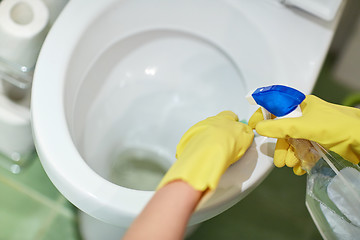 Image showing close up of hand with detergent cleaning toilet