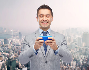 Image showing happy businessman texting on smartphone