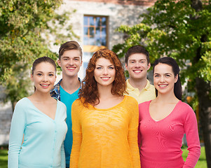 Image showing group of smiling teenagers over campus background