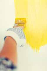 Image showing close up of male in gloves holding paintbrush