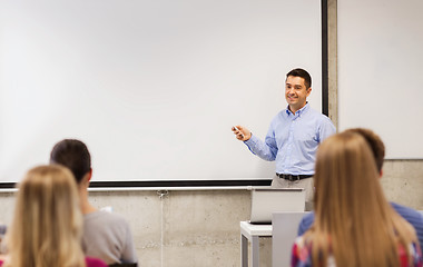 Image showing group of students and smiling teacher in classroom