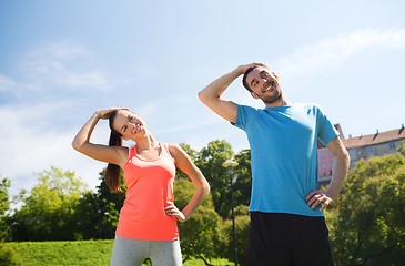 Image showing smiling couple stretching outdoors