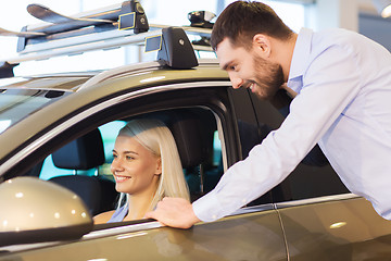 Image showing happy couple buying car in auto show or salon