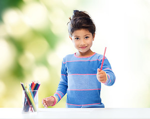 Image showing happy little girl drawing with coloring pencils