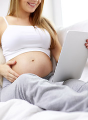 Image showing close up of pregnant woman with tablet pc at home