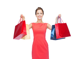 Image showing smiling elegant woman in dress with shopping bags