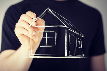 Image showing man drawing a house on virtual screen