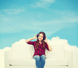 Image showing teenage girl sitting on sofa with headphones