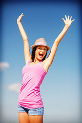 Image showing girl with hands up on the beach