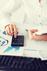 Image showing woman hand with calculator and papers