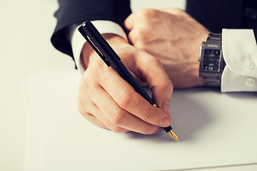 Image showing businessman writing something on the paper