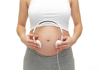 Image showing close up of pregnant woman and headphones on tummy