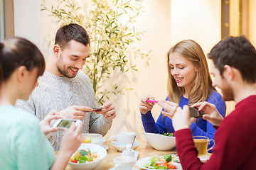 Image showing friends with smartphones taking picture of food