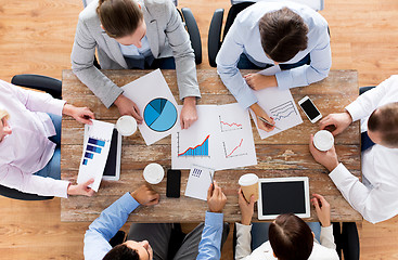 Image showing close up of business team with coffee and papers