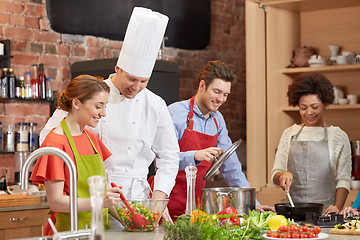 Image showing happy friends and chef cook cooking in kitchen