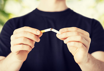 Image showing man breaking the cigarette with hands