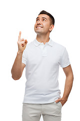 Image showing smiling man pointing finger up