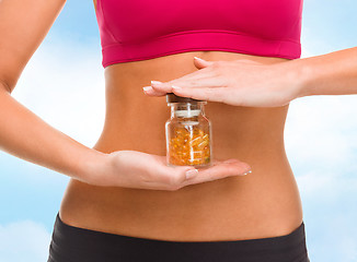 Image showing close up of female hands with bottle of capsules