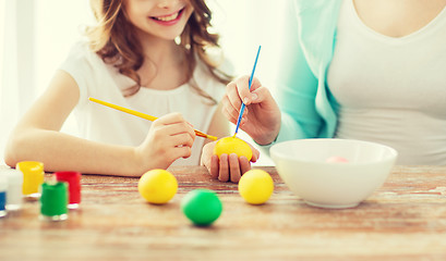 Image showing close up of little girl and mother coloring eggs