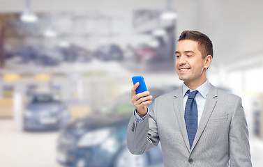 Image showing happy businessman texting on smartphone