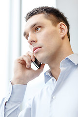 Image showing serious businessman with smartphone