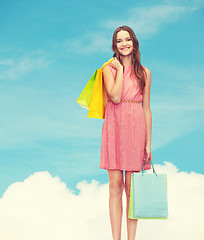 Image showing smiling woman in dress with many shopping bags
