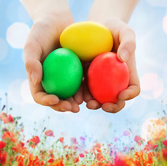 Image showing close up of kid hands holding colored eggs