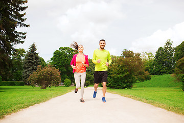 Image showing smiling couple running outdoors