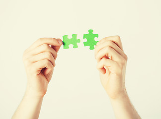 Image showing two hands trying to connect puzzle pieces