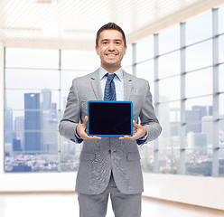 Image showing happy businessman in suit showing tablet pc screen