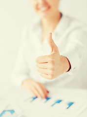 Image showing woman with charts, papers and thumbs up