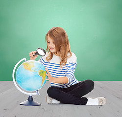 Image showing happy girl looking at globe with magnifier