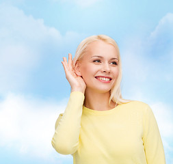 Image showing smiling young woman listening to gossip