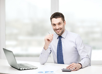 Image showing smiling businessman with laptop and documents