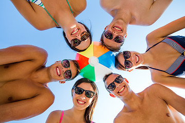 Image showing smiling friends in circle on summer beach