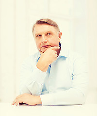 Image showing stressed old man holding head at home