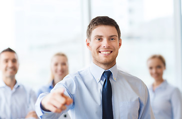 Image showing smiling businessman with colleagues in office