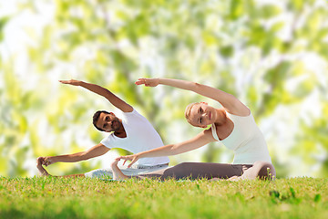 Image showing happy couple stretching and doing yoga exercises