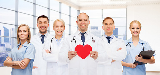 Image showing happy young doctors cardiologists with red heart