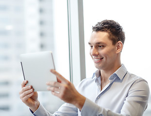 Image showing smiling businessman with tablet pc in office