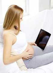 Image showing close up of pregnant woman with tablet pc at home