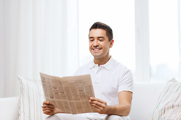 Image showing happy man reading newspaper at home