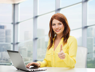 Image showing smiling young woman with laptop showing thumbs up