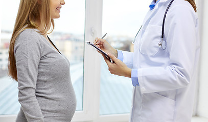 Image showing close up of happy pregnant woman and doctor