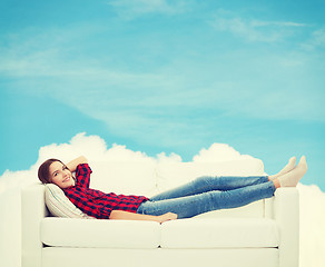 Image showing smiling teenage girl lying on sofa