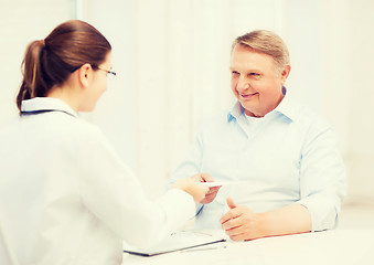 Image showing female doctor with old man giving prescription